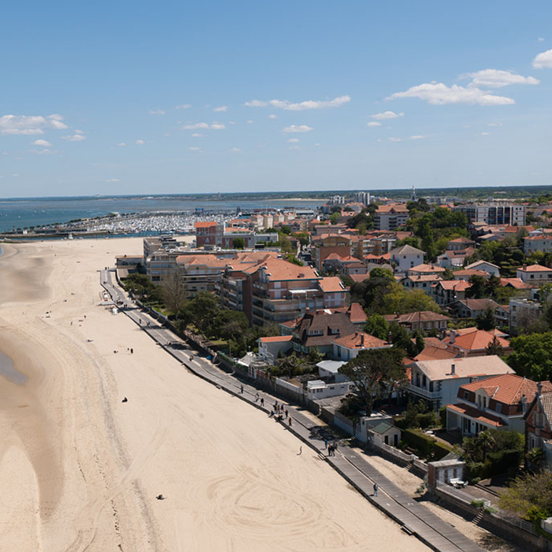 Vue de la ville et de la plage vers le port depuis une grande roue sur la jetée d'Eyrac