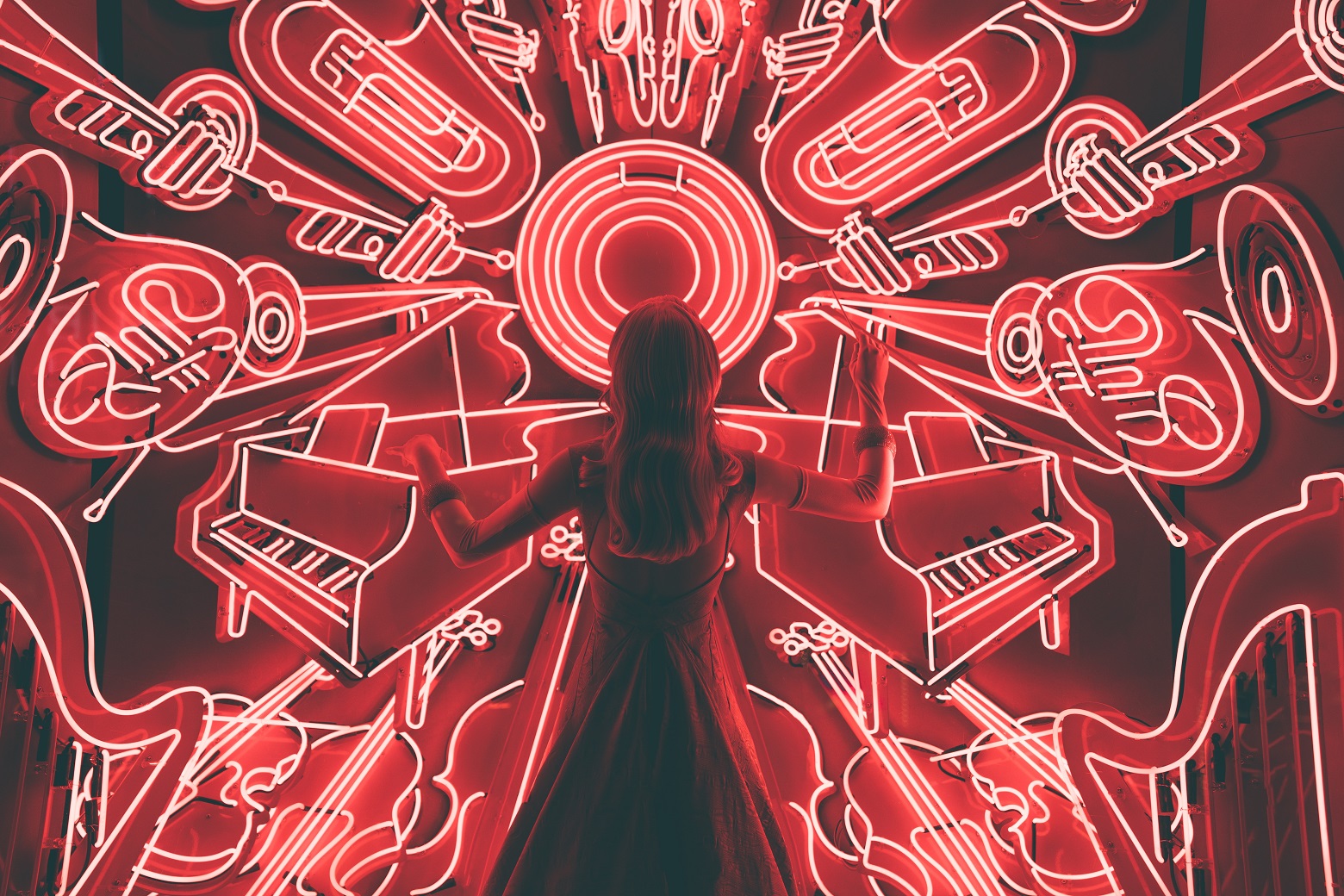 Femme devant des néons rouges représentants des instruments de musique