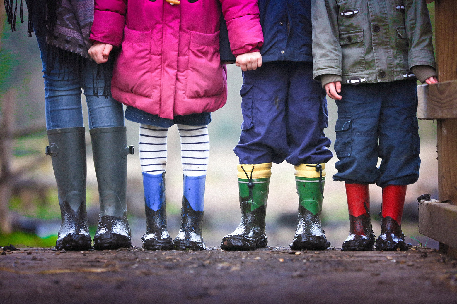 4 enfants portant des bottes de pluie